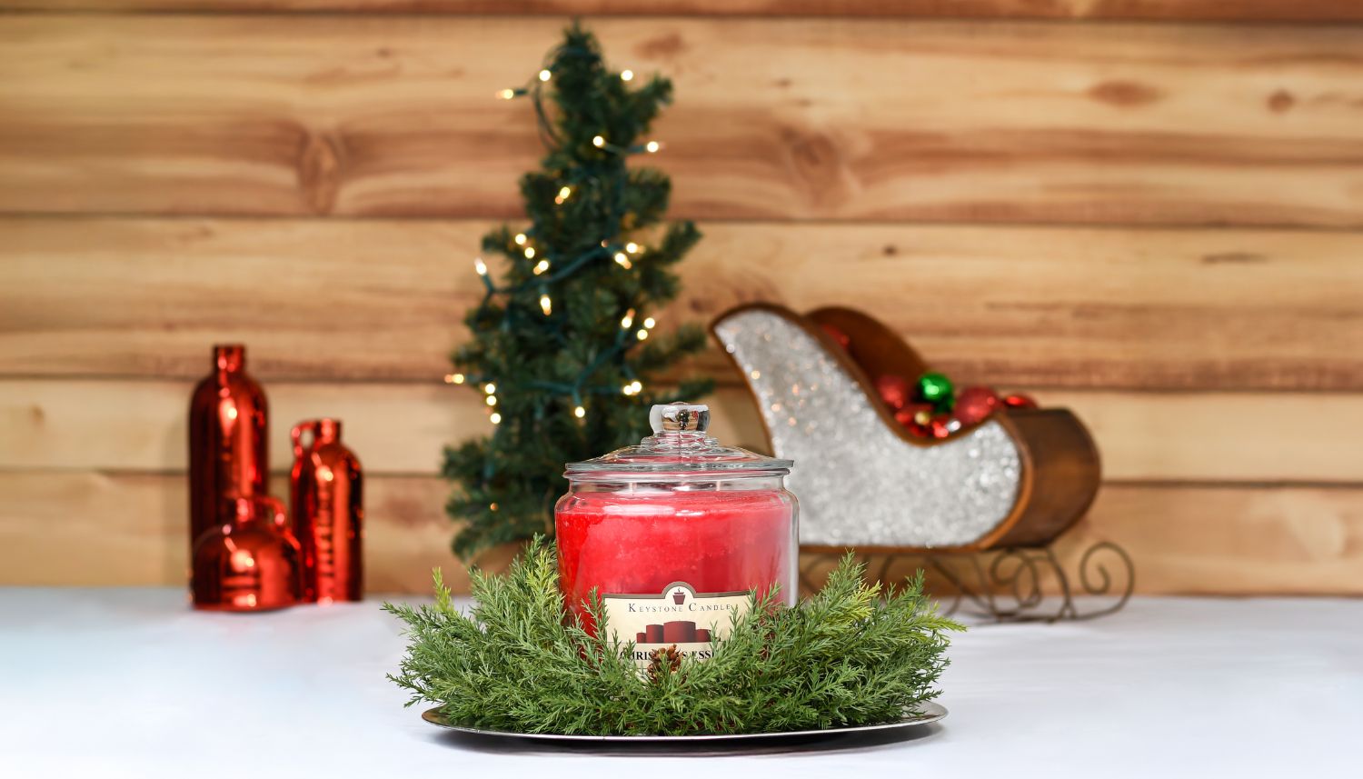 Red Christmas candle sits in front of Christmas decor