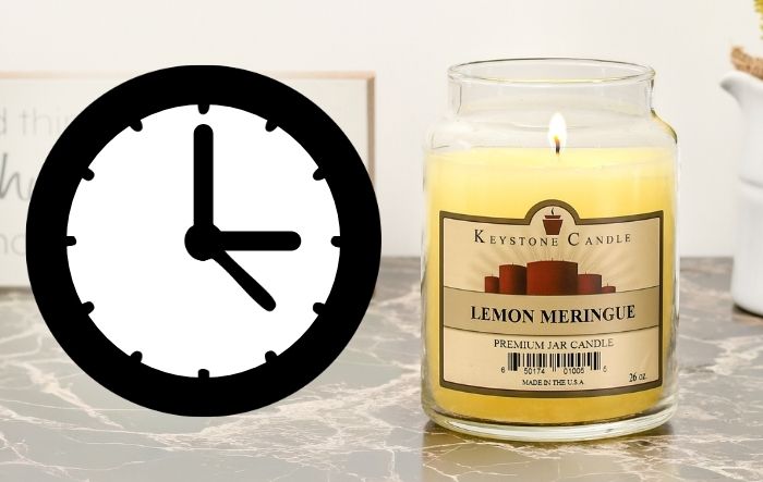 Lit candle next to a clock