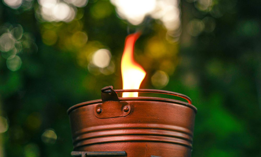 Lit itronella bucket candle outside in the late evening