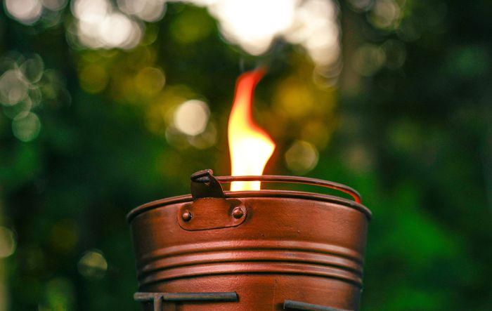 Lit itronella bucket candle outside in the late evening